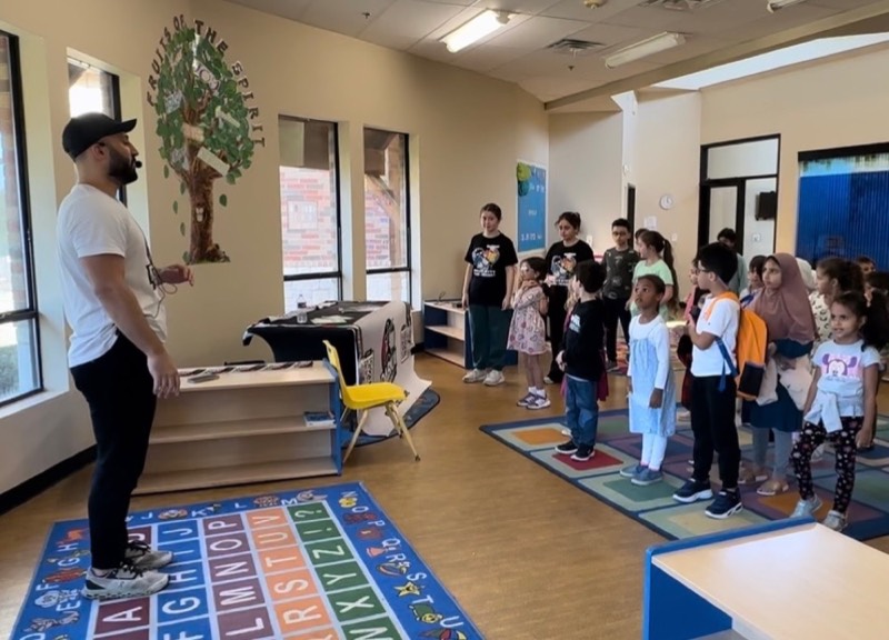Yusuf teaching Middle Eastern folklore dance to a room of students